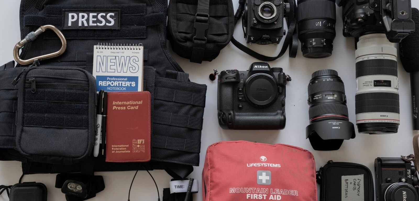 Daniel Wheeler's essential equipment for conflict reporting, including press body armor, cameras, and medical supplies.